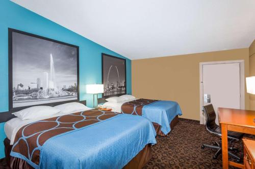 a hotel room with two beds and a desk at Super 8 by Wyndham Belleville St. Louis Area in Belleville