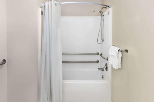 a shower with a white shower curtain in a bathroom at Super 8 by Wyndham Biloxi Ocean Springs in Ocean Springs
