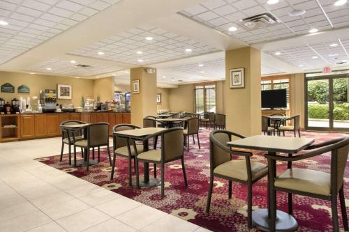 a waiting area with tables and chairs in a cafeteria at Wingate by Wyndham - Chattanooga in Chattanooga