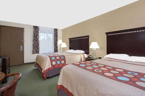 Habitación de hotel con 2 camas y mesa en Super 8 by Wyndham Danville, en Danville