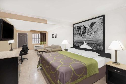 a hotel room with a bed and a flat screen tv at Super 8 by Wyndham McAllen-Downtown-Airport-LA Plaza Mall in McAllen