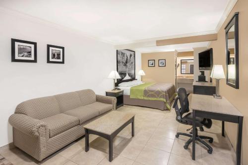 a hotel room with a bed a couch and a desk at Super 8 by Wyndham McAllen-Downtown-Airport-LA Plaza Mall in McAllen
