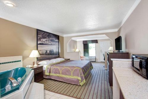 a hotel room with a bed and a television at Super 8 by Wyndham Knoxville East in Knoxville