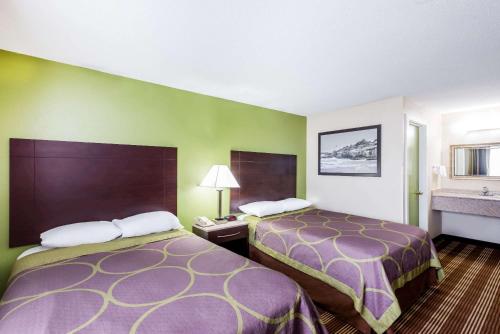 a hotel room with two beds and a sink at Super 8 by Wyndham Bangor in Bangor