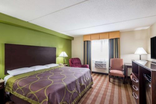 a hotel room with a bed and a desk at Super 8 by Wyndham Bangor in Bangor