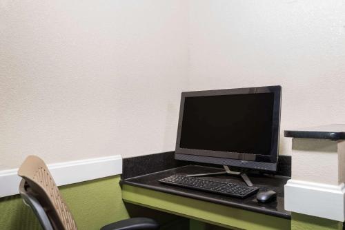 a computer monitor and a keyboard and mouse on a desk at Super 8 by Wyndham Bangor in Bangor