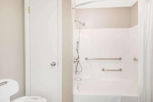 uma casa de banho com um chuveiro e um WC. em Super 8 by Wyndham Chattanooga Ooltewah em Ooltewah