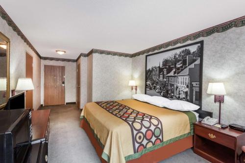 a hotel room with a bed with a painting on the wall at Super 8 by Wyndham Erwin, I-26 Exit 37 in Erwin