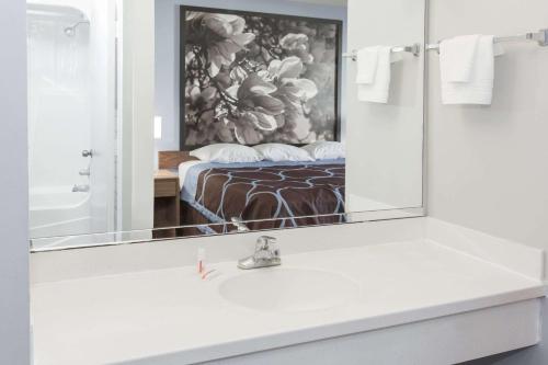 a bathroom with a sink and a mirror at Super 8 by Wyndham Valdosta GA I-75 in Valdosta
