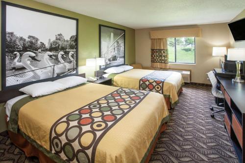 a hotel room with two beds and a flat screen tv at Super 8 by Wyndham Dwight in Dwight