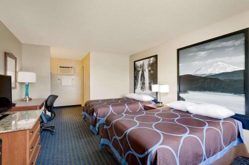 a hotel room with a large bed and a desk at Super 8 by Wyndham Alturas in Alturas