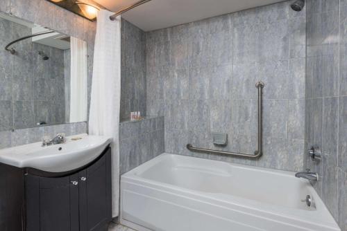 y baño con bañera blanca y lavamanos. en Super 8 by Wyndham Guelph, en Guelph