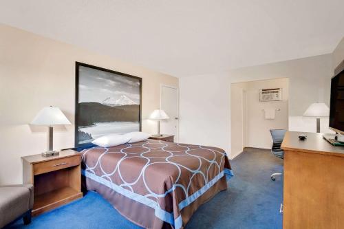 a hotel room with a bed and a couch at Super 8 by Wyndham Alturas in Alturas