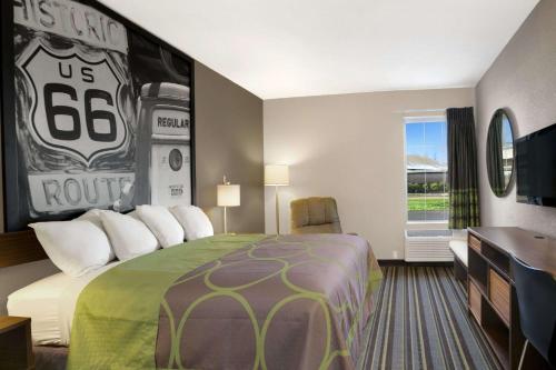 a hotel room with a bed with a football sign on the wall at Super 8 by Wyndham Stafford/Springfield Area in Strafford