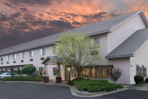 a large white building with a tree in front of it at Super 8 by Wyndham Sparta in Sparta