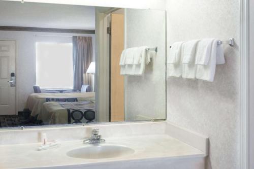 ein Badezimmer mit Waschbecken und Spiegel in der Unterkunft Super 8 by Wyndham Ashburn in Ashburn