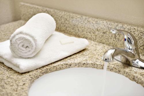 a bathroom sink with a towel on a counter at Super 8 by Wyndham Lakeland in Lakeland