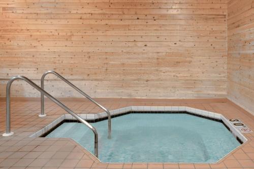 a jacuzzi tub in a room with wooden walls at Super 8 by Wyndham Sparta in Sparta