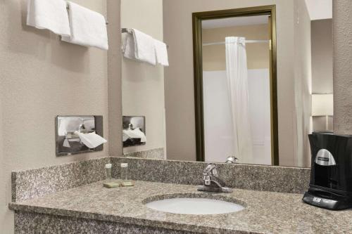 a bathroom with a sink and a mirror at Super 8 by Wyndham Stafford/Springfield Area in Strafford