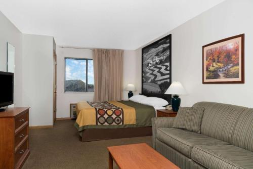 a hotel room with a bed and a couch at Super 8 by Wyndham Sparta in Sparta
