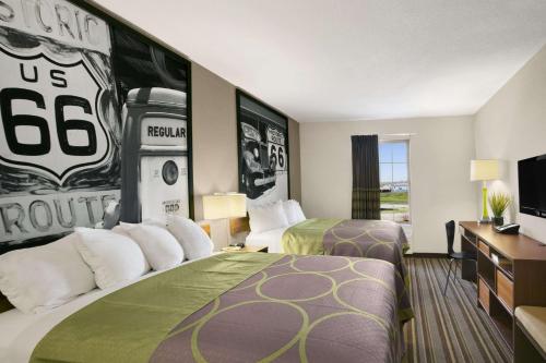 ein Hotelzimmer mit 2 Betten und einem Fußballbild in der Unterkunft Super 8 by Wyndham Stafford/Springfield Area in Strafford