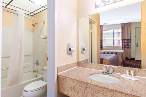 W łazience znajduje się umywalka, toaleta i lustro. w obiekcie Super 8 by Wyndham Temple S General Bruce w mieście Temple