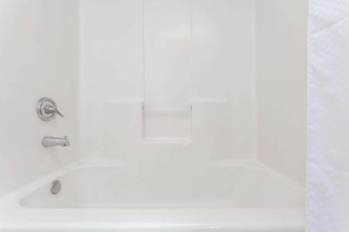 a white bath tub with a faucet in a bathroom at Super 8 by Wyndham Cottonwood in Cottonwood