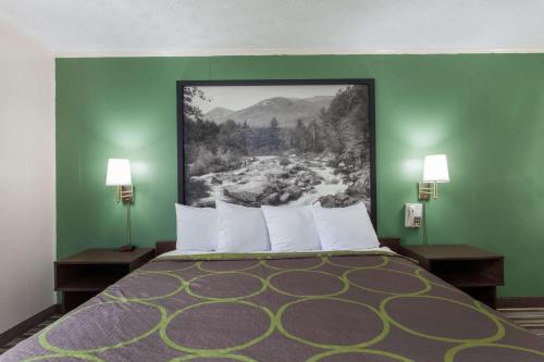 a bedroom with a bed with a painting on the wall at Syracuse Inn in East Syracuse