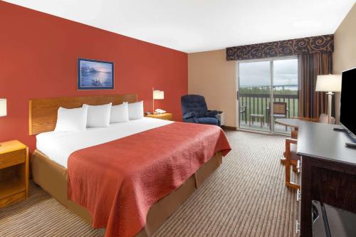 una habitación de hotel con una cama y un balcón en Super 8 by Wyndham St. Ignace, en Saint Ignace