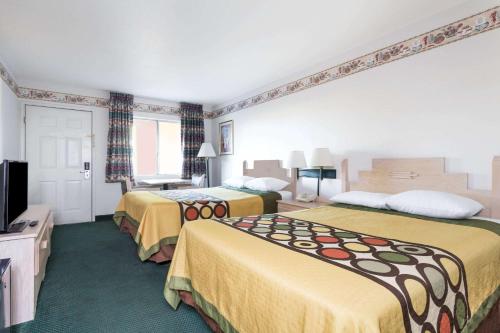 a hotel room with two beds and a television at Super 8 by Wyndham Cottonwood in Cottonwood