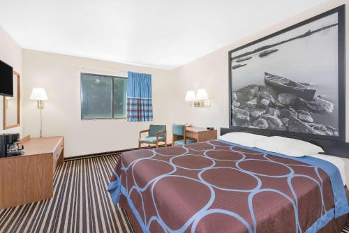a large hotel room with a bed and a desk at Super 8 by Wyndham Morris in Morris