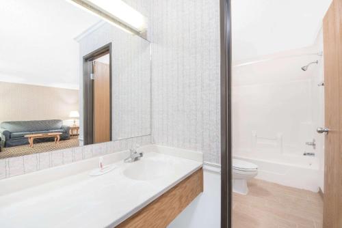 a bathroom with a sink and a toilet and a mirror at Wrangler Hotel Morris in Morris