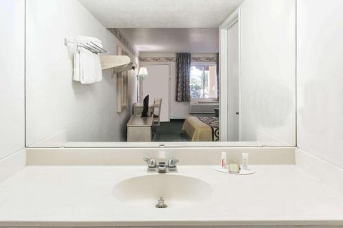 uma casa de banho com um lavatório e um espelho grande em Super 8 by Wyndham Cottonwood em Cottonwood