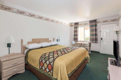 a hotel room with a bed and a television at Super 8 by Wyndham Cottonwood in Cottonwood