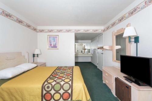 a hotel room with a bed and a flat screen tv at Super 8 by Wyndham Cottonwood in Cottonwood