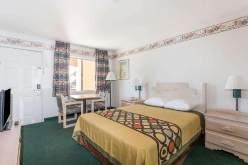 a hotel room with a bed and a desk at Super 8 by Wyndham Cottonwood in Cottonwood