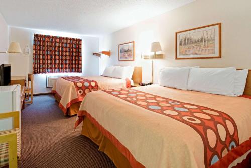 a hotel room with two beds and a window at Super 8 by Wyndham Plano/Dallas Area in Plano