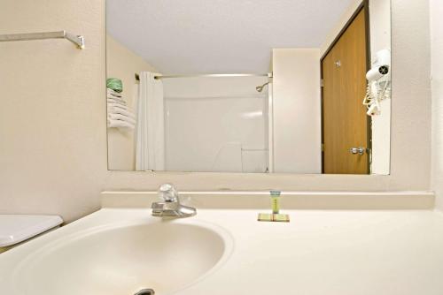 a bathroom with a sink and a mirror at Super 8 by Wyndham Plano/Dallas Area in Plano