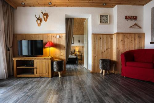 a living room with a television and a red couch at Landhaus Danita in Bodensdorf