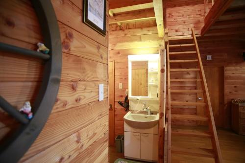 a bathroom with a sink and a staircase in a log cabin at Stay in Toya in Lake Toya