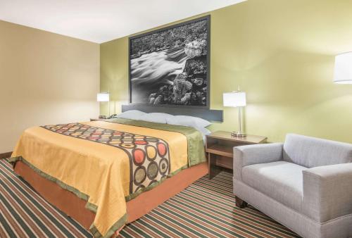 a hotel room with a bed and a chair at Super 8 by Wyndham Bryant Little Rock Area in Bryant