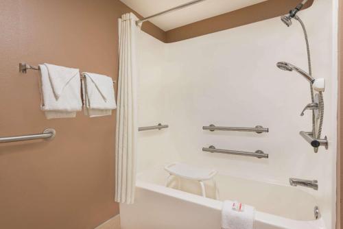 a bathroom with a tub and a toilet and towels at Super 8 by Wyndham Bryant Little Rock Area in Bryant