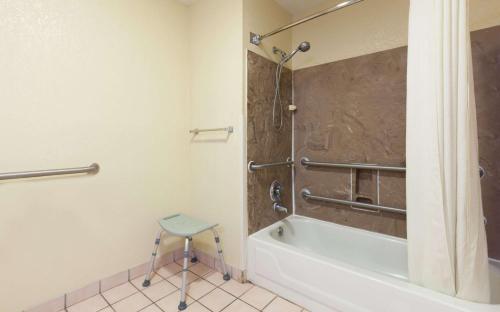 a bathroom with a shower and a stool in it at Super 8 by Wyndham Hammond in Hammond