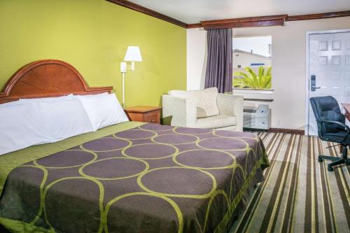 una camera d'albergo con letto e sedia di Super 8 by Wyndham San Marcos a San Marcos