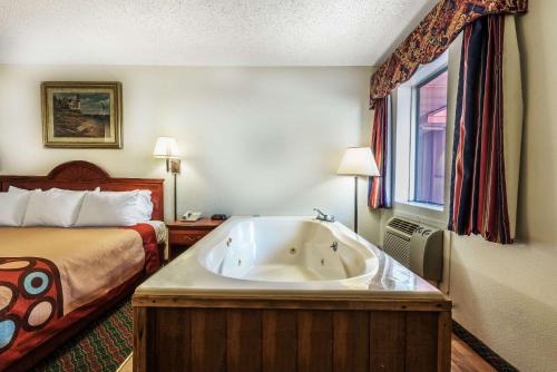 a hotel room with a large bath tub next to a bed at Super 8 by Wyndham Eastland in Eastland
