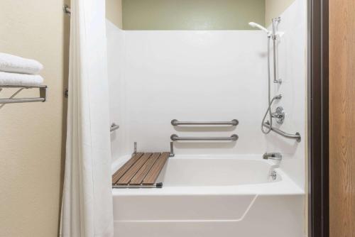 a bathroom with a white tub and a sink at Super 8 by Wyndham Greenville in Greenville