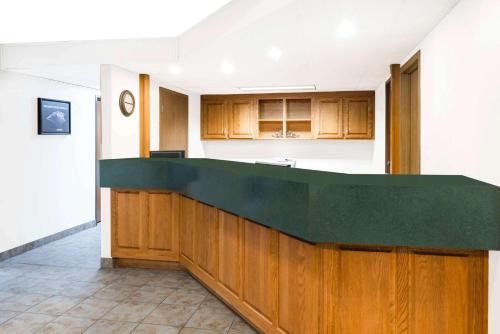 a kitchen with wooden cabinets and a green counter top at Super 8 by Wyndham Bolivar in Bolivar