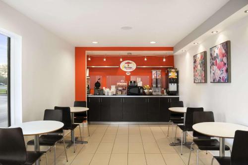 a restaurant with tables and chairs and a counter at Super 8 by Wyndham Ormond Beach in Ormond Beach