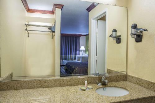 a bathroom with a sink and a large mirror at Super 8 by Wyndham San Marcos in San Marcos