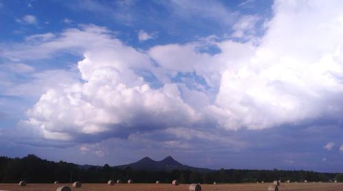 a cloudy sky with hay bales in a field at U Leknínu in Doksy